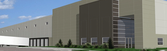 Modern building facade with large glass windows and landscaped greenery.