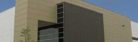 Modern building corner with beige and dark panels under a blue sky.