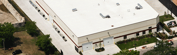 A large commercial warehouse with loading docks and white roof.