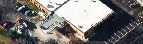 Aerial view of a building with a damaged or collapsed roof.