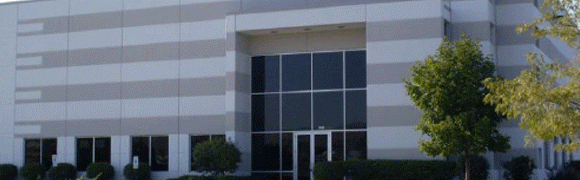Modern office building entrance with glass doors and windows.