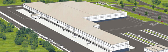 Large industrial warehouse with surrounding greenery.