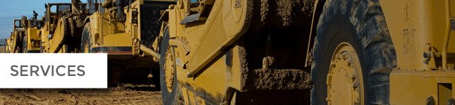 Close-up of a muddy yellow bulldozer track and arm.