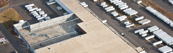 Aerial view of warehouse and parked trucks.