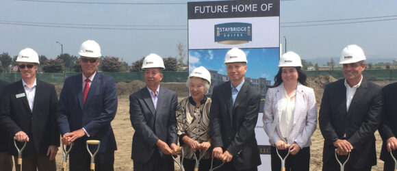 People at groundbreaking ceremony wearing hard hats.