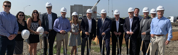 Group at construction site with shovels.
