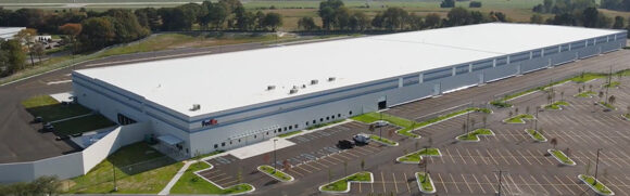 Large warehouse building with parking lot.